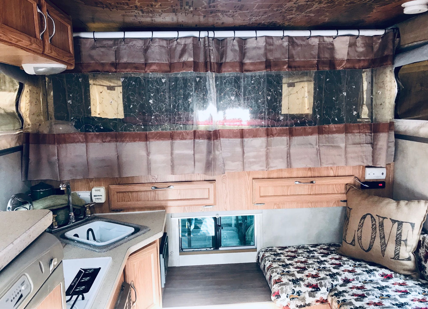 and "HOME" pillow for adventures.|Cozy RV rental interior with a comfy bed