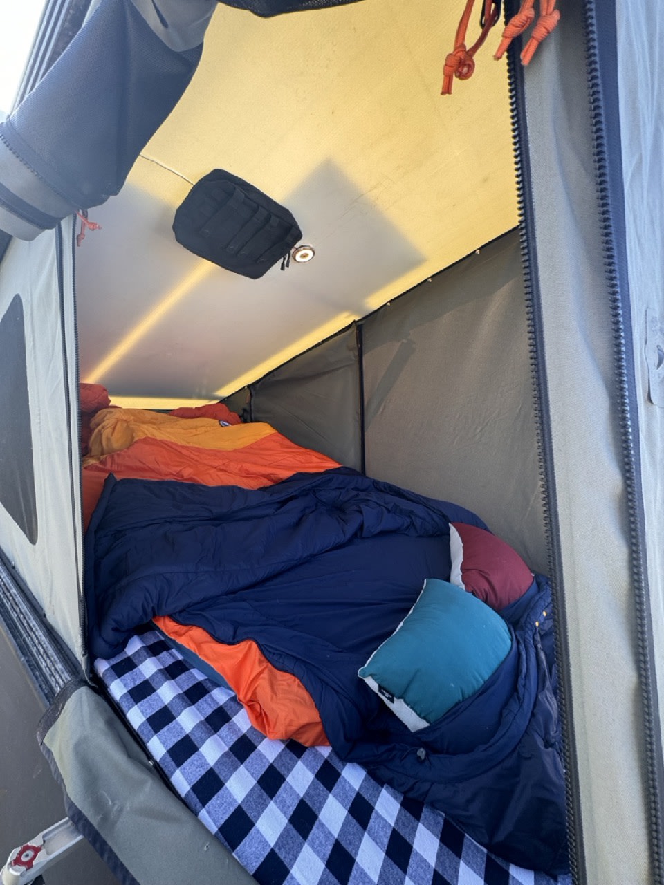 Inside an RV rental camping tent: a cozy bed with colorful blankets & pillows. Ready for adventure!