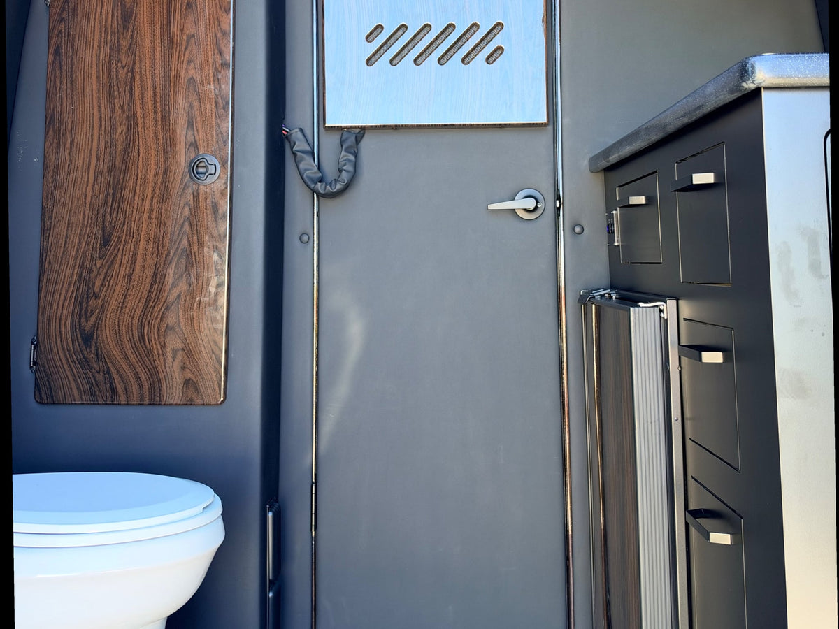and elegant wood paneling.|Luxurious RV rental interior with two tan — photo 12
