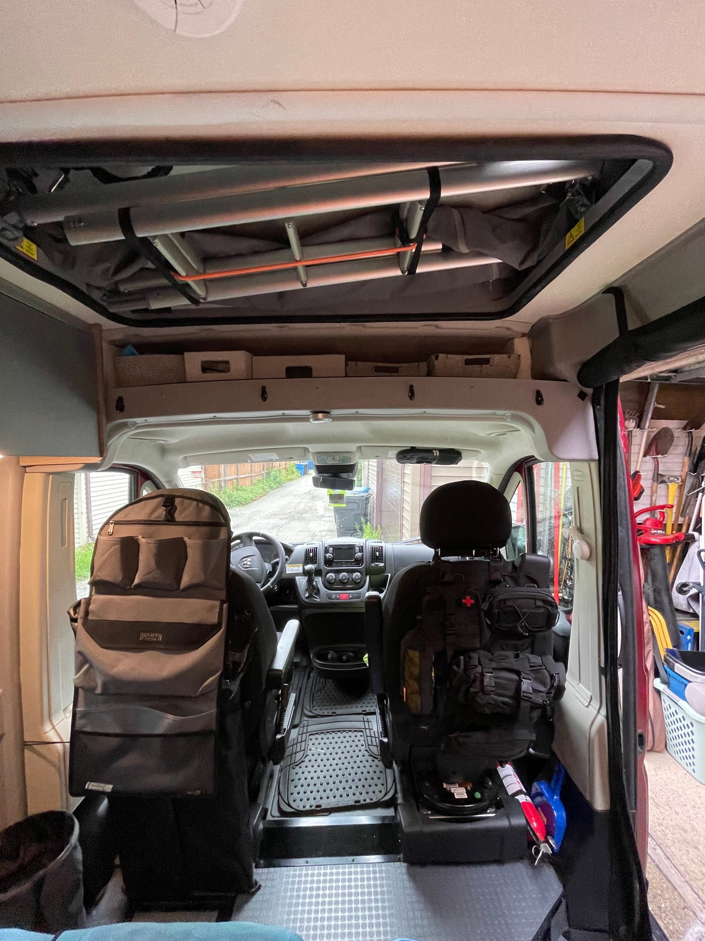 RV rental interior: A camper van's organized front cabin with seat organizers and overhead storage for travel essentials.