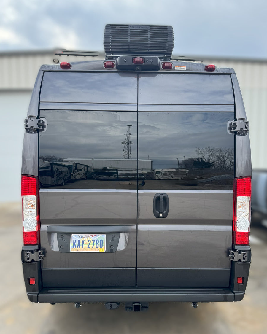 Rear view of a grey camper van, an ideal RV rental, with Ohio plate, roof AC, and hitch. Ready for adventure!