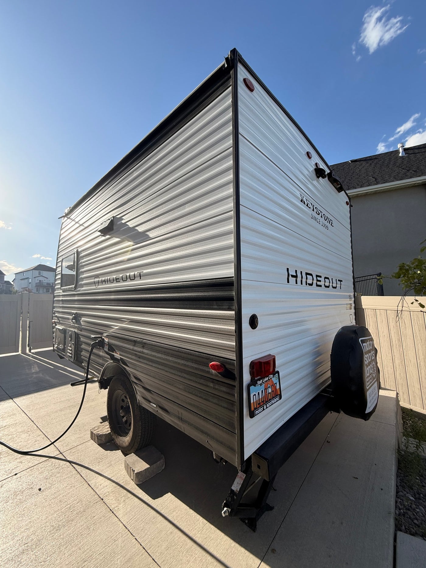 This Keystone Hideout travel trailer (RV) is parked in a driveway, power connected. Ready for your next RV rental adventure. — photo 2