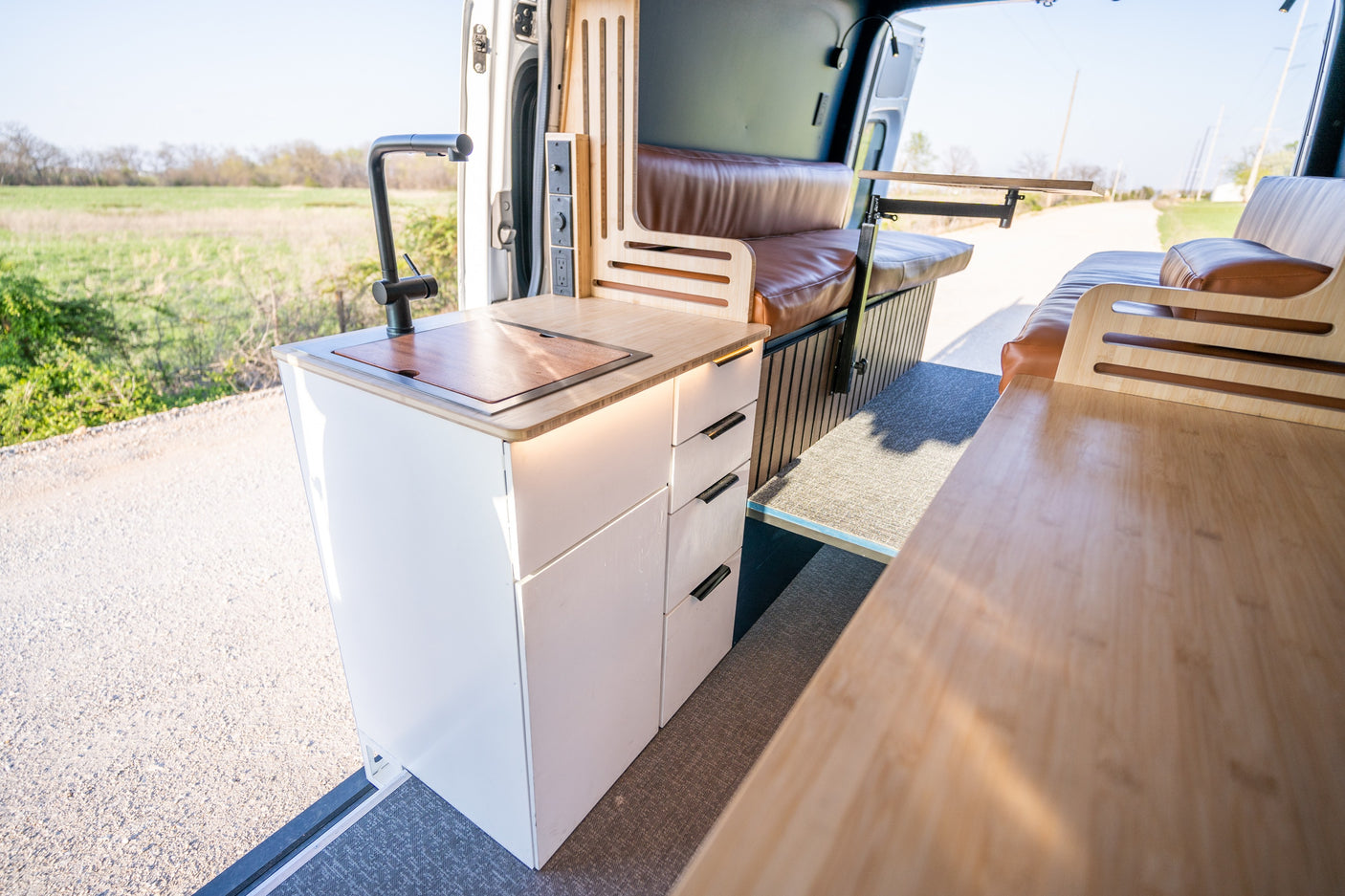 Stylish camper van kitchen and seating area with a view, perfect for an RV rental escape.
