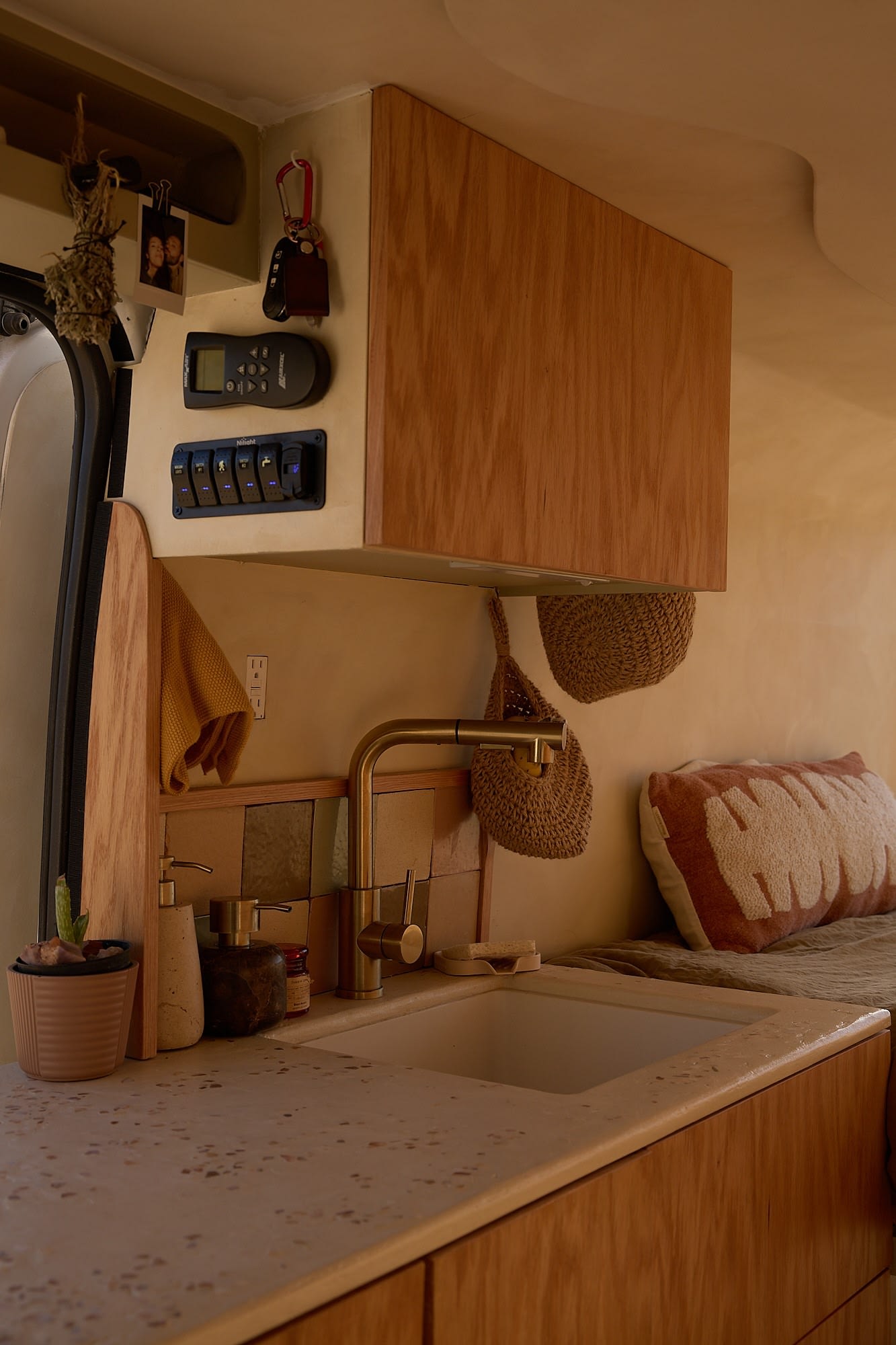 and a desert view through the back window.|Inside an rv rental: a comfy bed with warm blankets