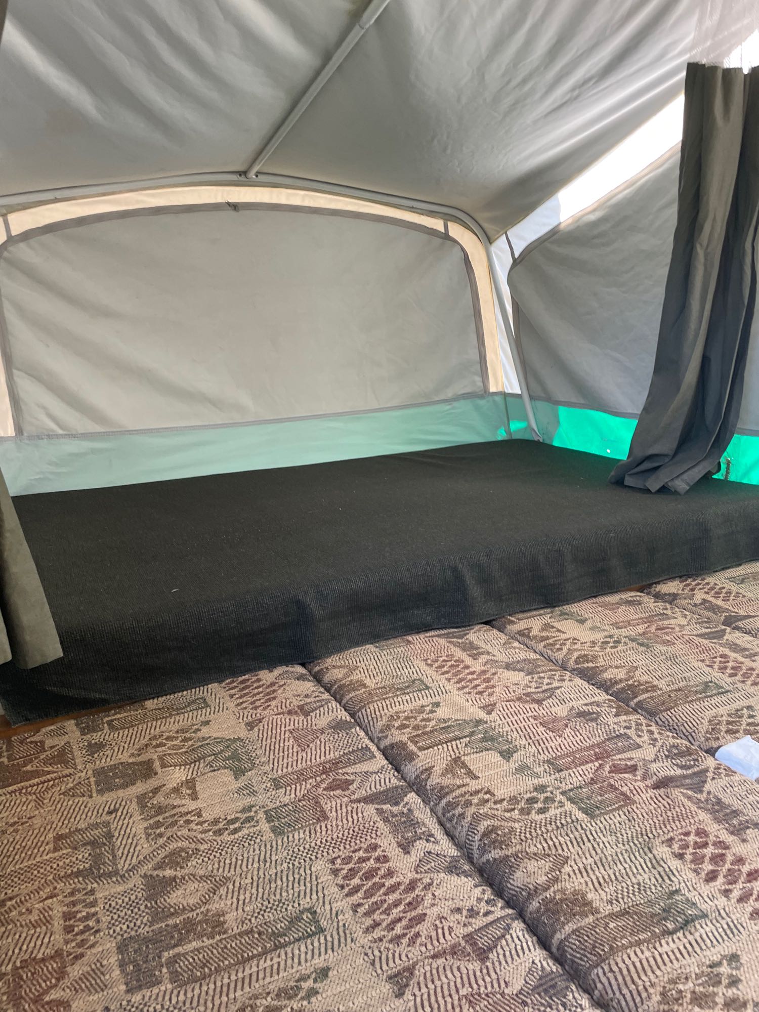 and compact kitchen with sink.|Learn about your pop-up camper: a 2003 Coleman Folding Trailer owner's manual. Perfect before an RV rental adventure.|RV rental pop-up camper interior: a compact kitchen with a shiny stainless steel sink and an open two-burner stove.|An LP gas leak detector