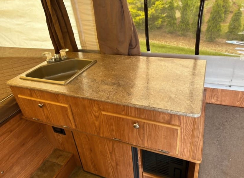 and wood-toned floors.|A Rockwood pop-up camper