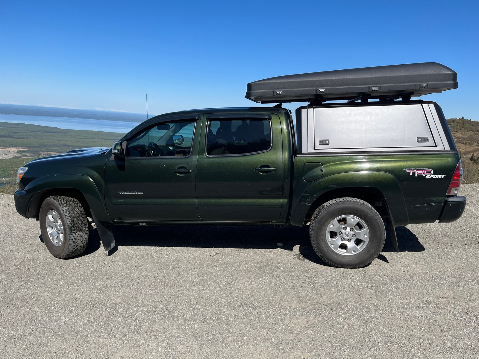 Adventure-ready green Tacoma with truck cap & cargo box. Ideal for your next outdoor RV rental road trip.