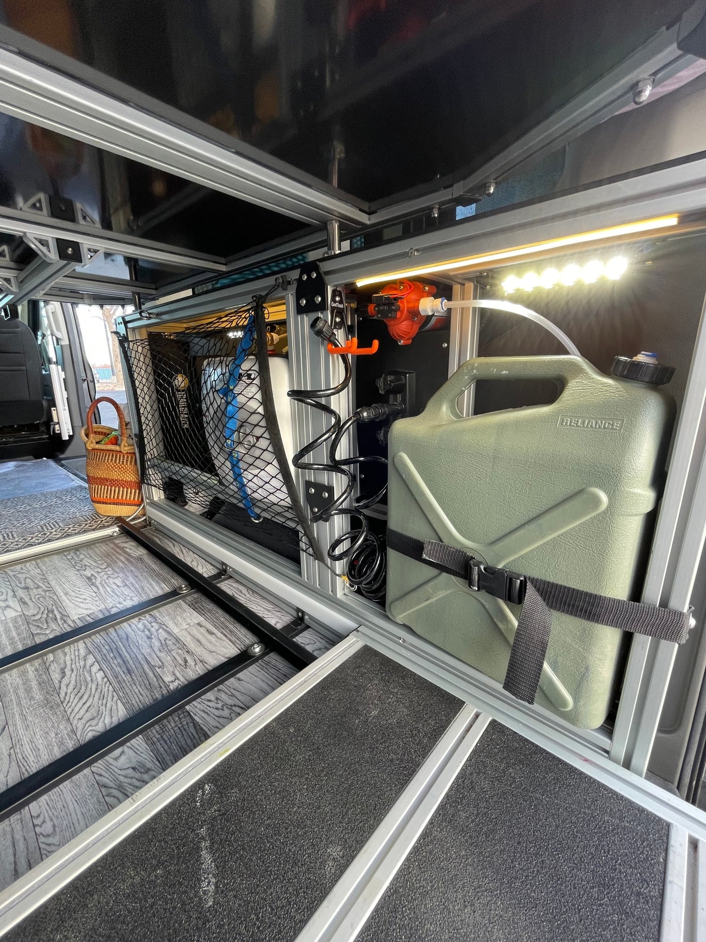 Custom RV rental interior features modular storage, an efficient water pump system with tank, and a pull-out platform.