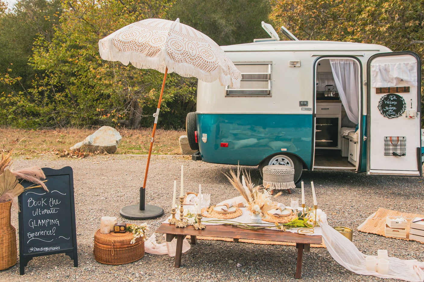 Elegant glamping scene: a vintage RV rental with a chic outdoor dining setup, perfect for a luxurious escape.