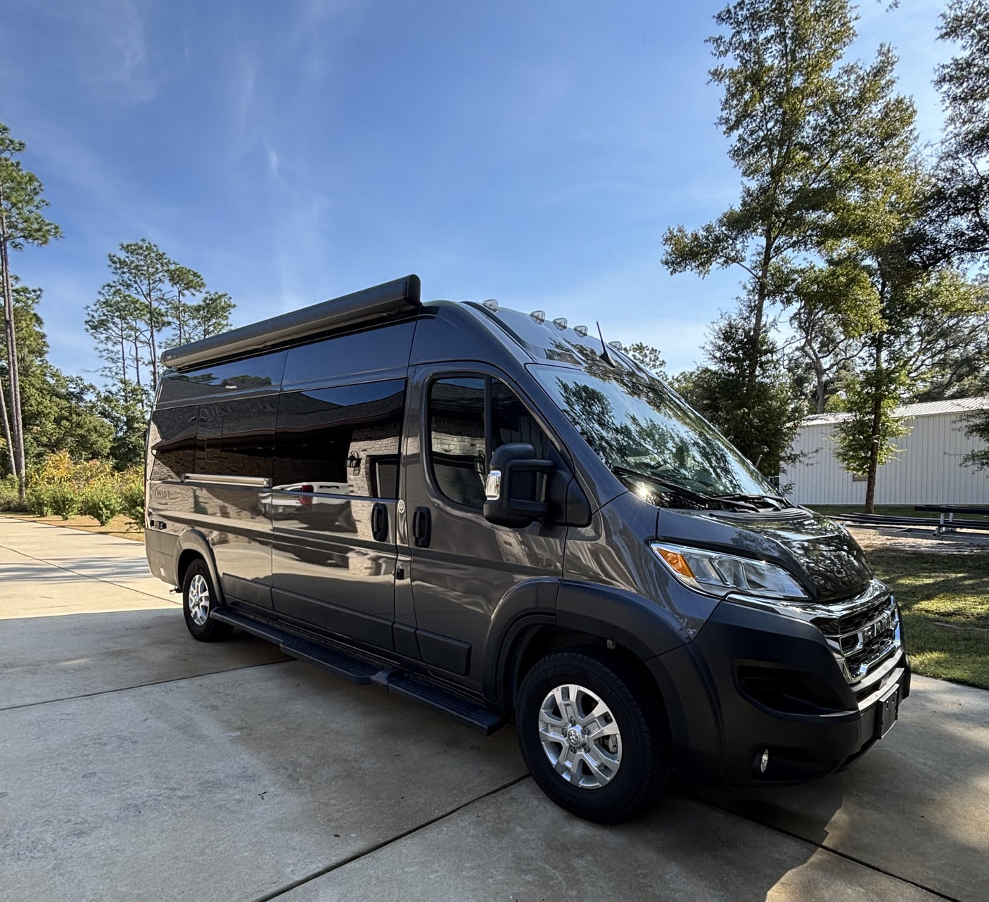ideal for RV rental adventures. "TWIST" branded on the rear.|A modern dark grey rv rental camper van parked on concrete