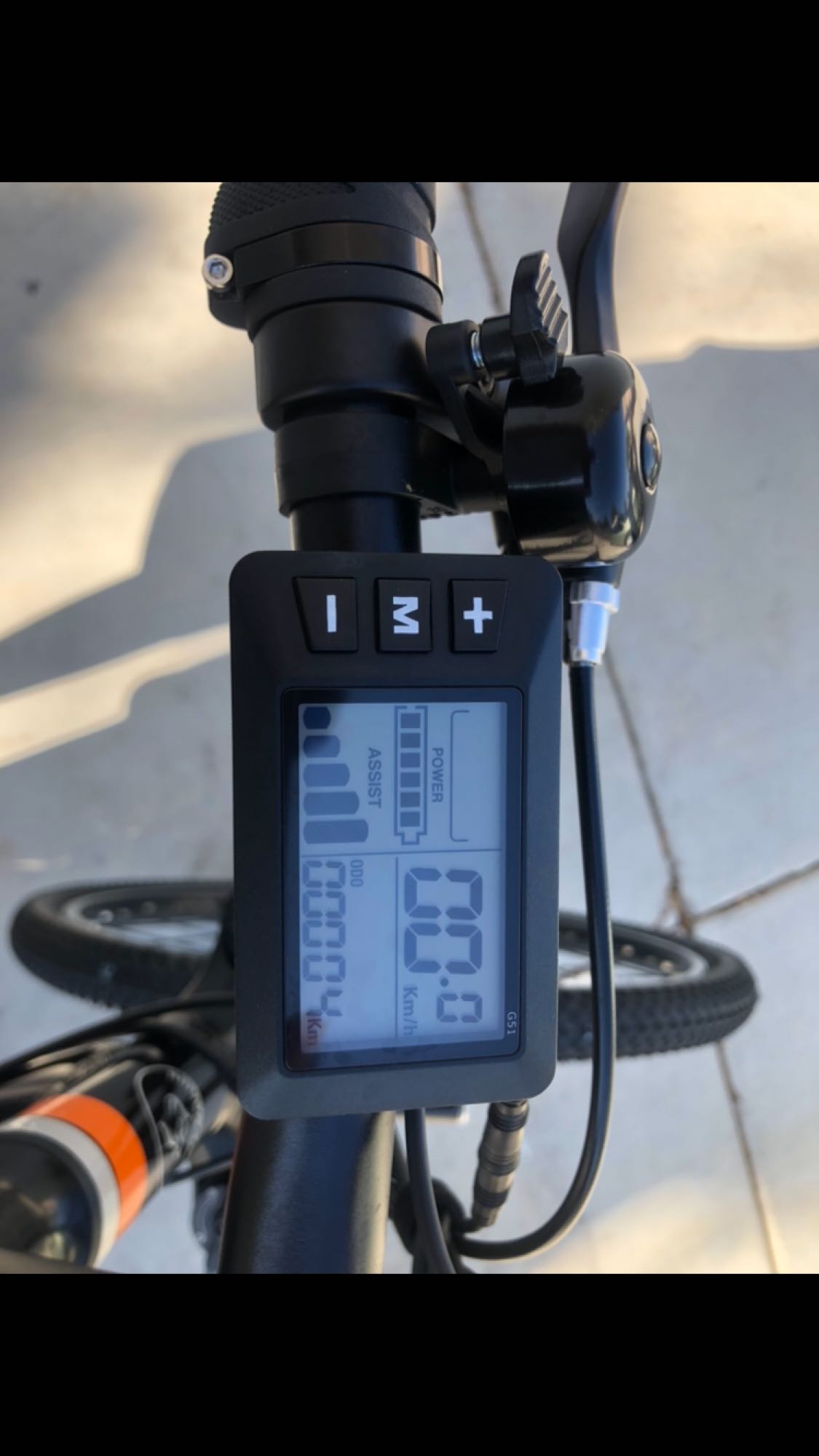 Close-up of an e-bike's digital display on the handlebar showing 0.4 km odometer, battery & speed. Great for RV rental.