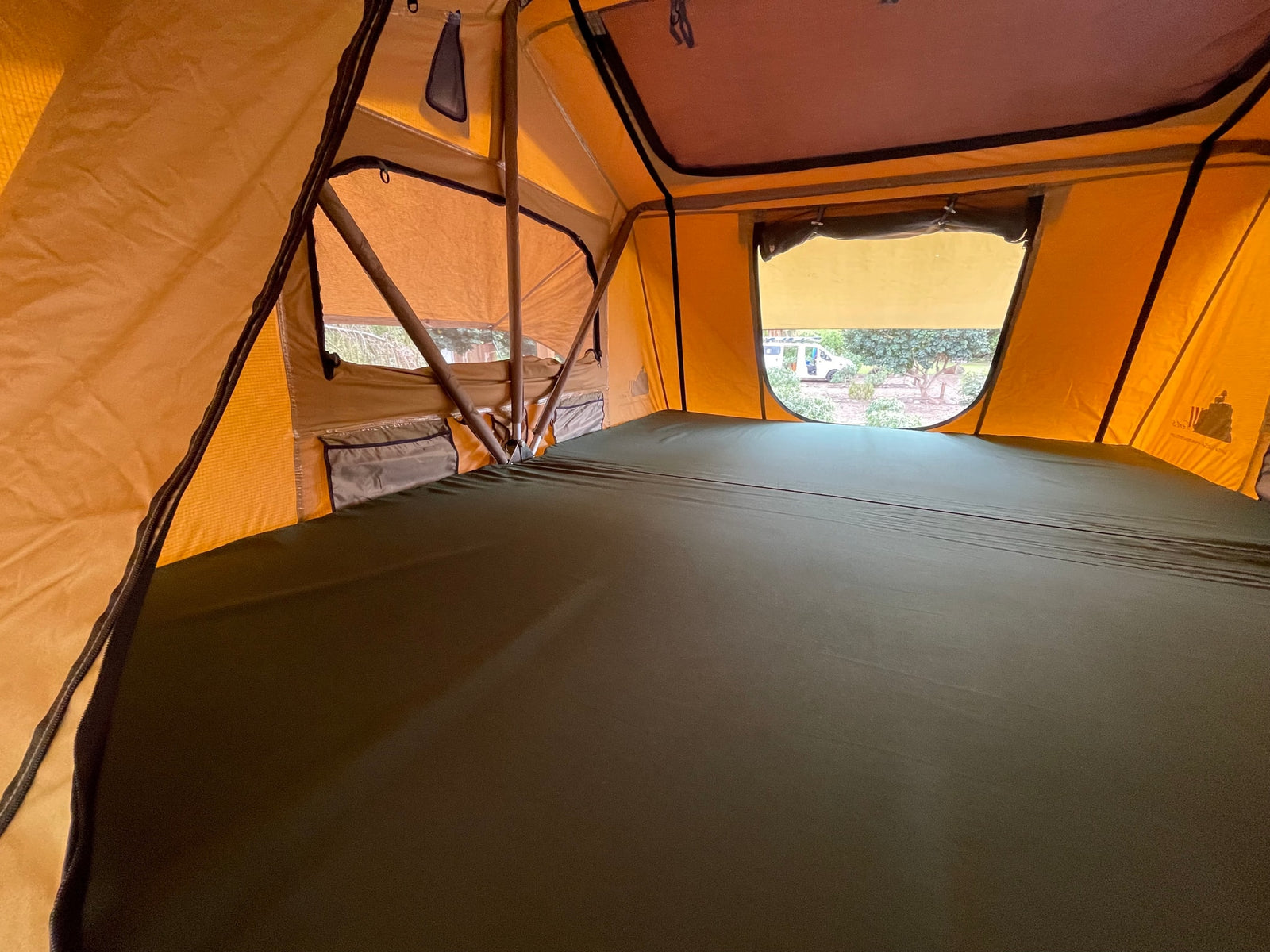 Interior of a cozy rooftop tent with a bed, providing a comfortable sleeping space for your RV rental journey.