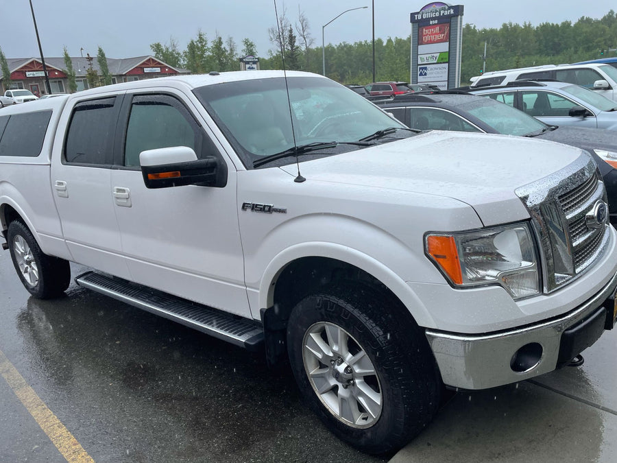 White Ford F-150 pickup truck with a camper shell