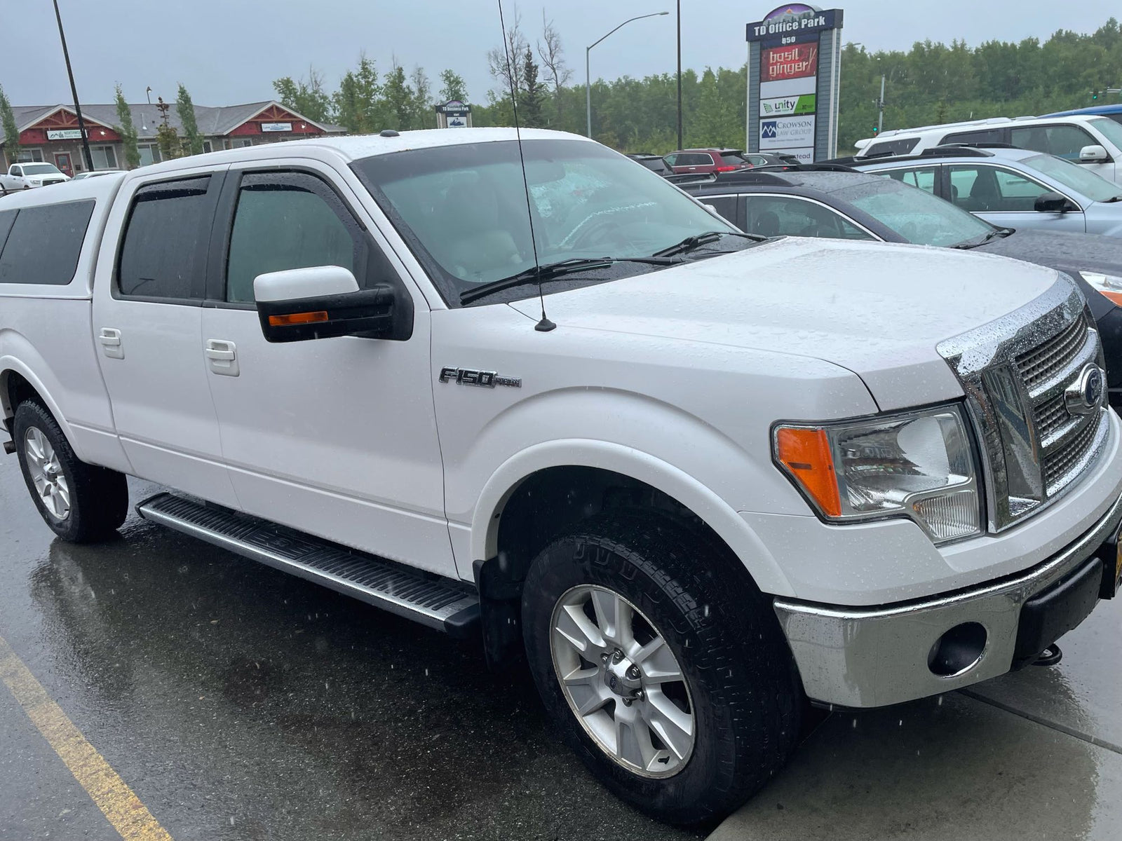 White Ford F-150 pickup truck with a camper shell