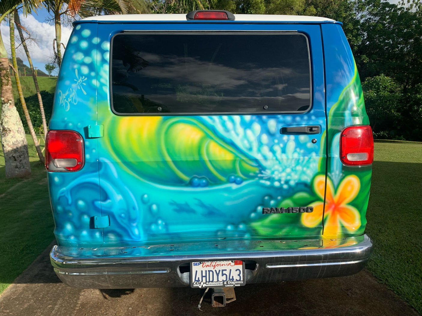 Eye-catching RV rental: a custom-painted blue Ram 1500 van featuring a vibrant surf and wave mural on its rear.
