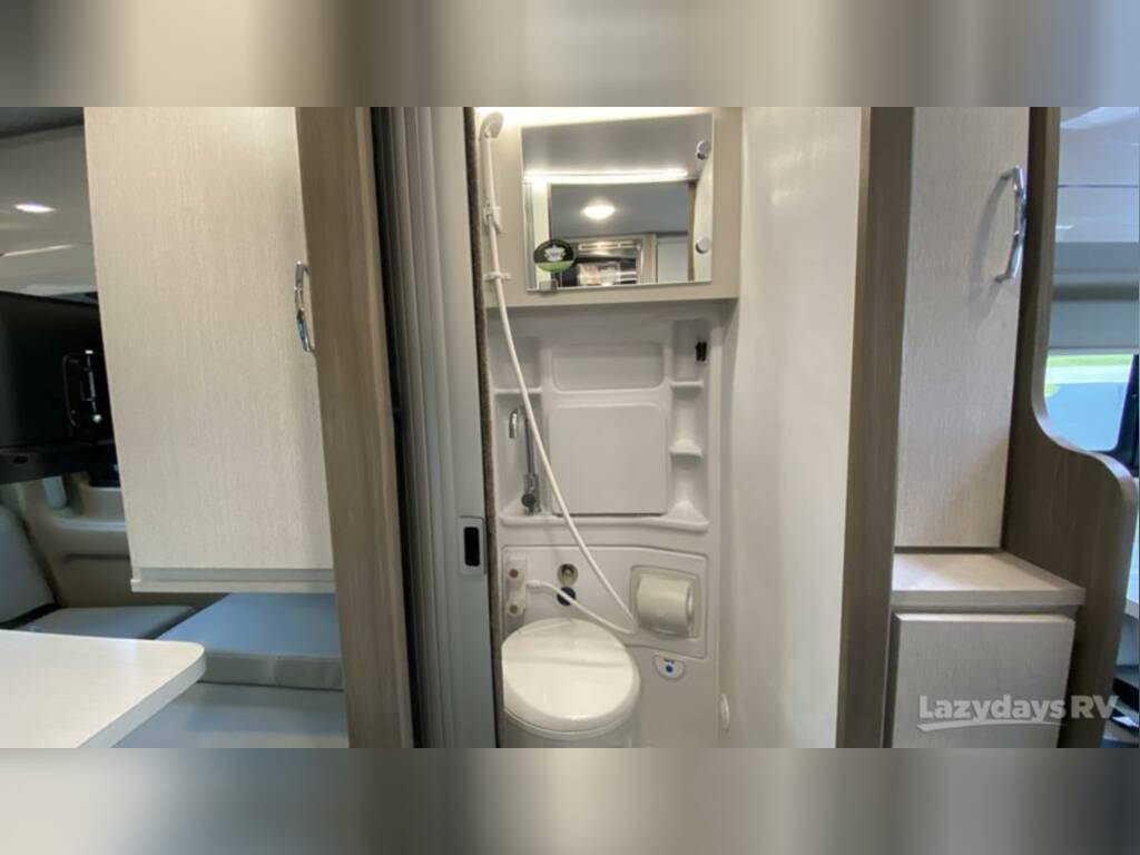Compact RV rental interior: wet bath with toilet and shower. Modern design for comfortable travel.