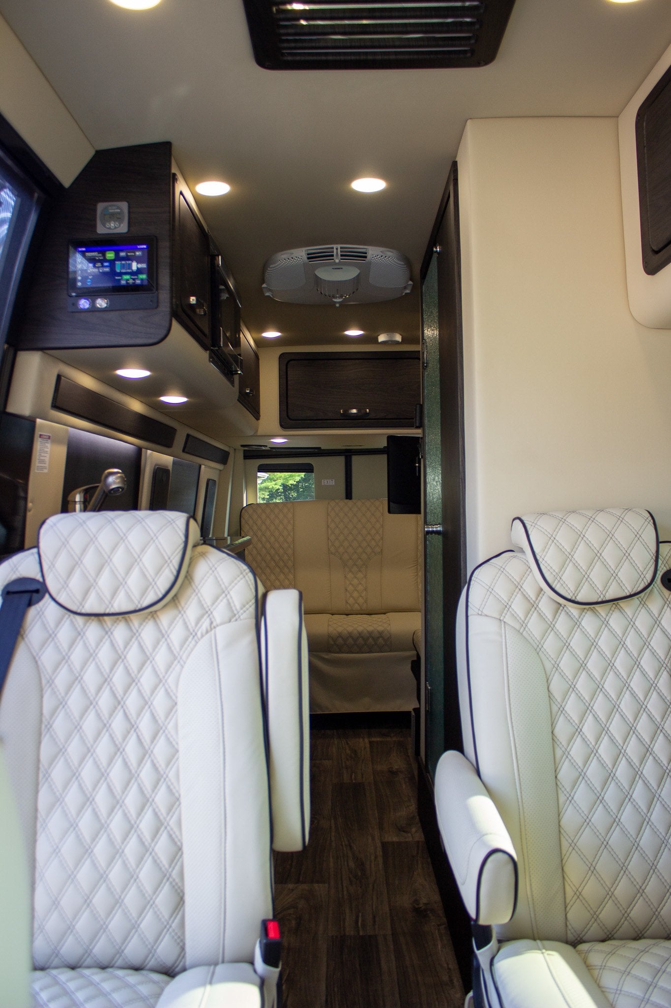 revealing its interior.|Luxurious RV rental interior showcasing plush quilted white seating