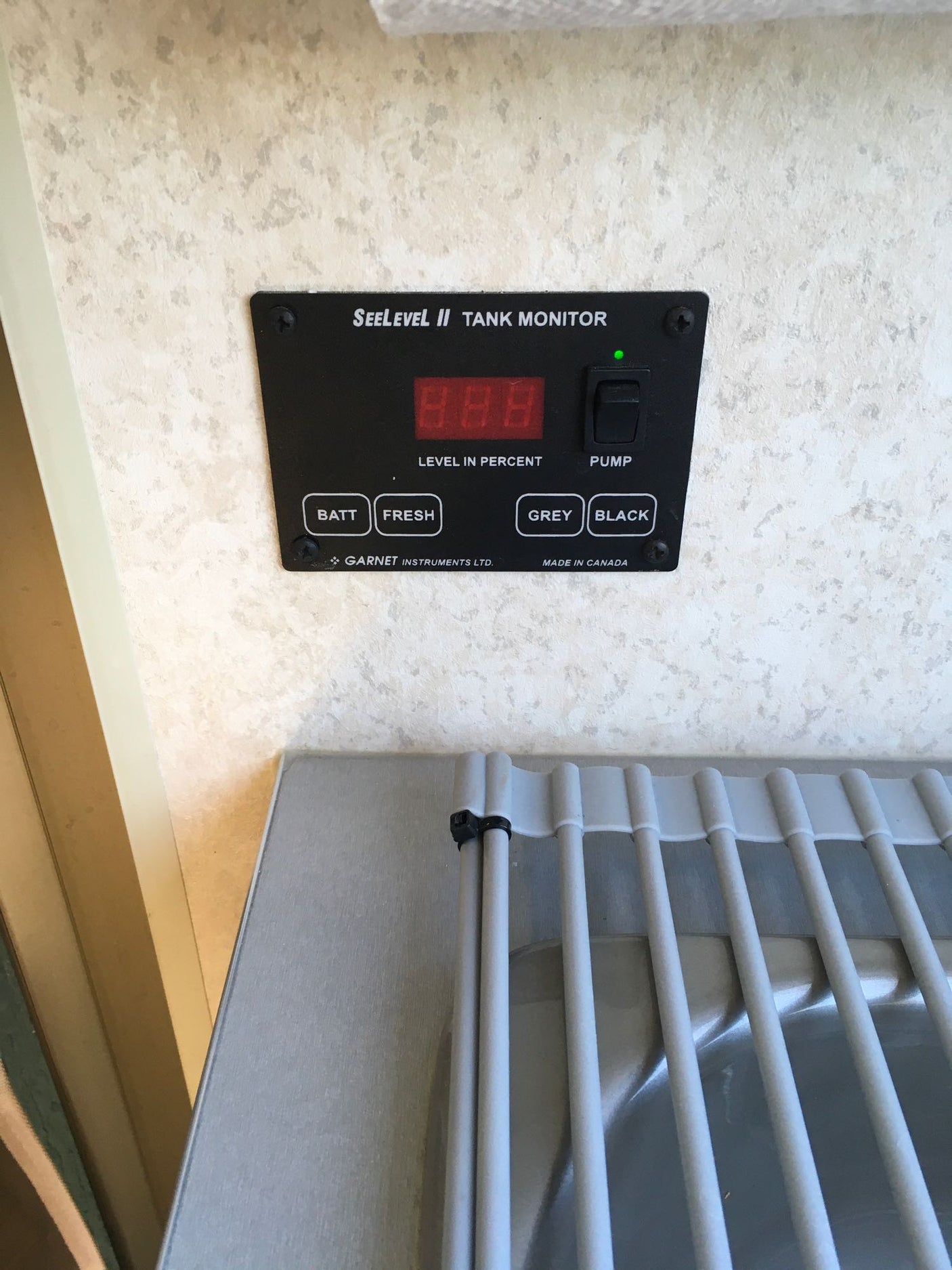 Essential for any **rv rental**: the SeeLevel II tank monitor displaying water/battery levels and pump switch.