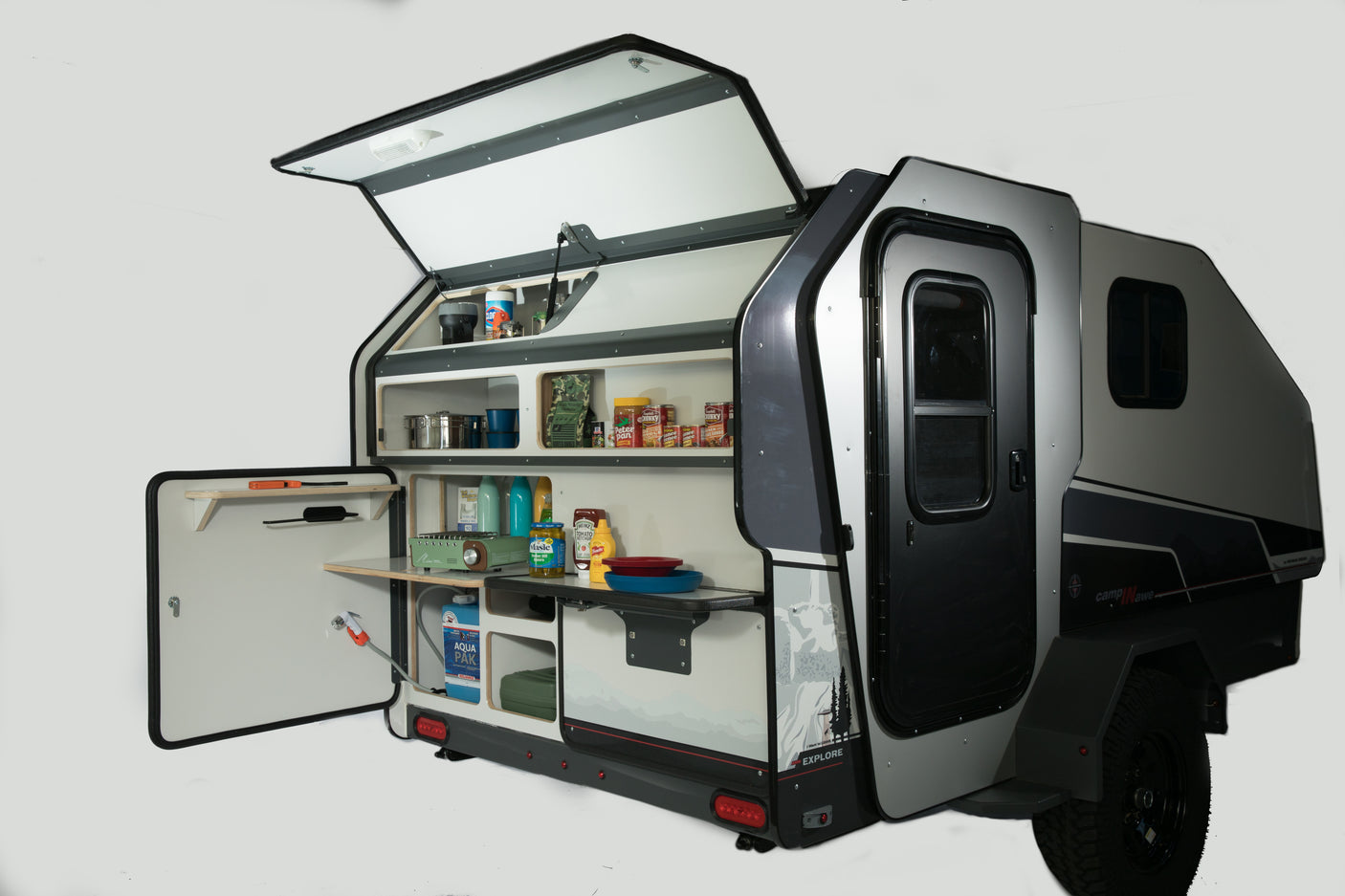 Compact rv rental teardrop camper showing open rear galley kitchen, fully stocked with a stove and supplies for outdoor adventure.