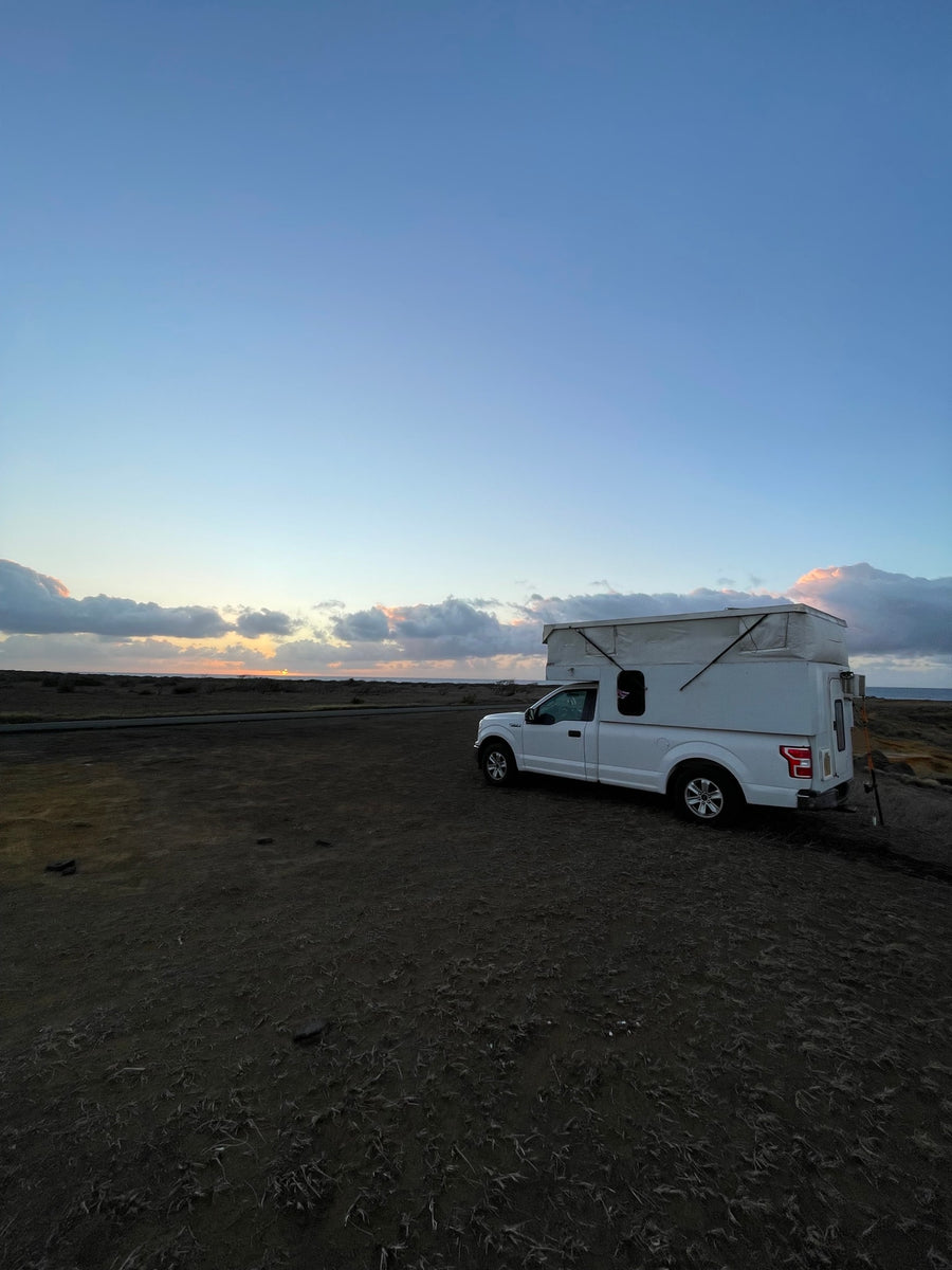 parked on grass with doors open under a blue sky