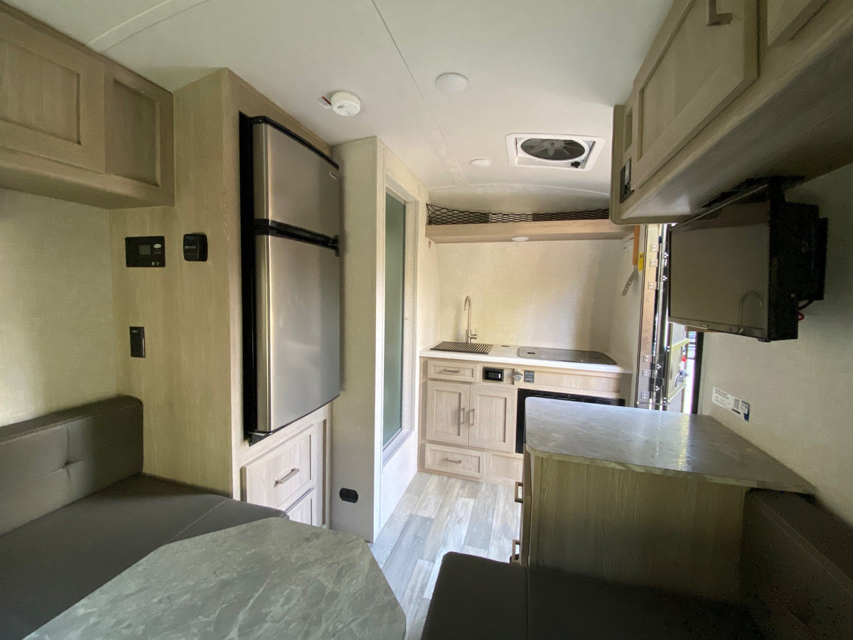 and snowy patch.|RV rental interior: A compact kitchen with sink/stove — photo 3