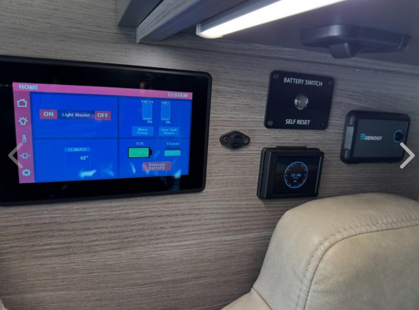 Inside an RV rental, a digital control panel displays lights, climate, water tanks, and Renogy battery status.