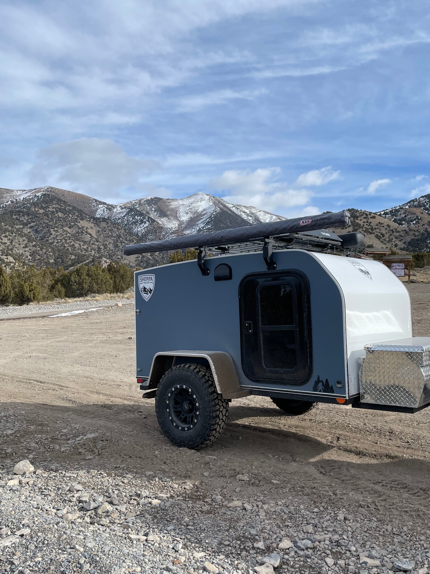 Rugged teardrop camper, ideal for an RV rental mountain adventure. Ready for off-grid exploration in the snow-capped terrain.