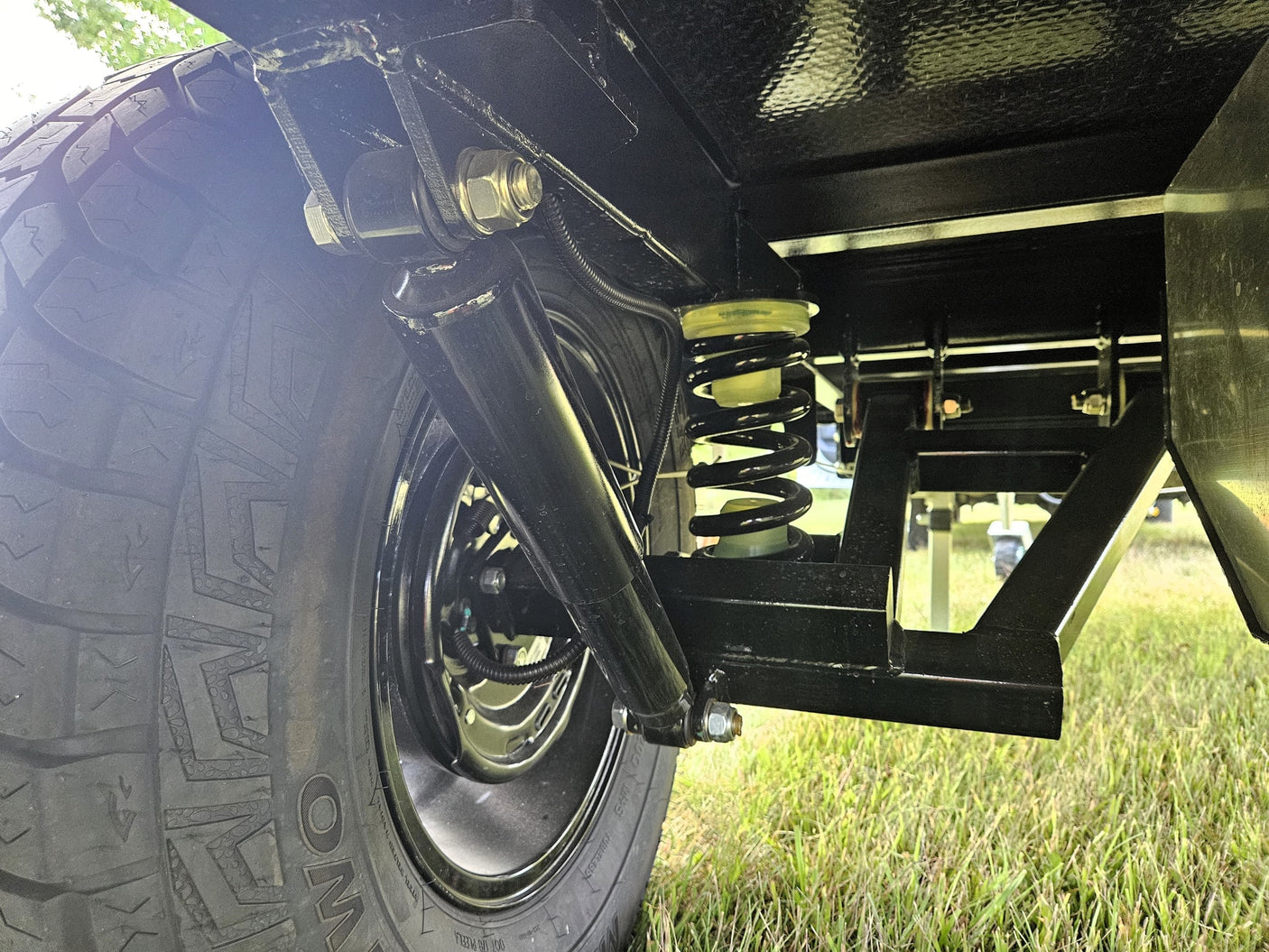 and ceiling net storage.|This black OTG camper/RV rental features a convenient slide-out storage tray & shelving for camping gear.|Black OTG camper trailer with pull-out solar panel & rooftop tent for your next RV rental adventure.|Detail of an RV rental's rear: LED lights