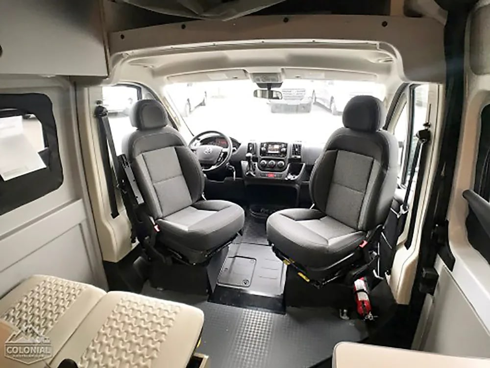 plus versatile seating for travel comfort.|Clean RV rental interior: A cream bench seat with textured details