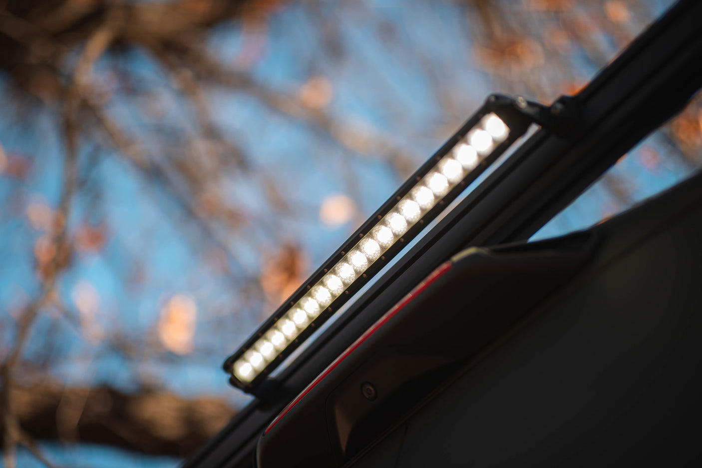 Illuminated LED light bar on an RV rental, enhancing visibility for outdoor adventures. Blurred sky background.