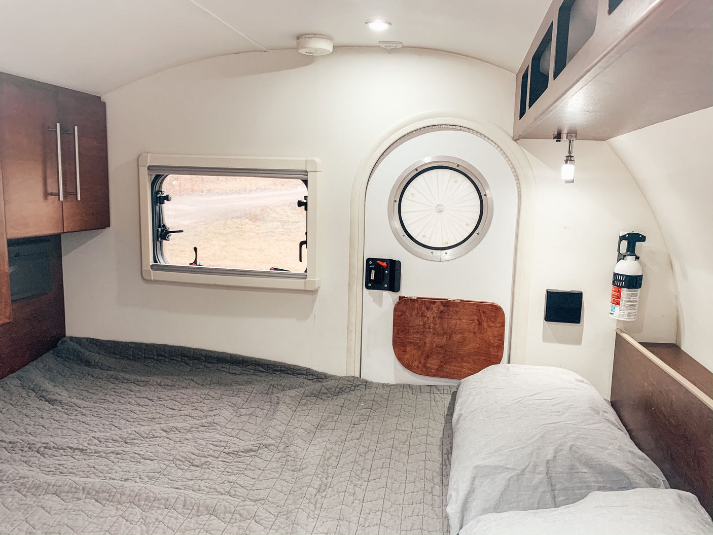 is hitched to an SUV in a sunny parking lot.|Explore this RV rental's clever rear outdoor kitchen