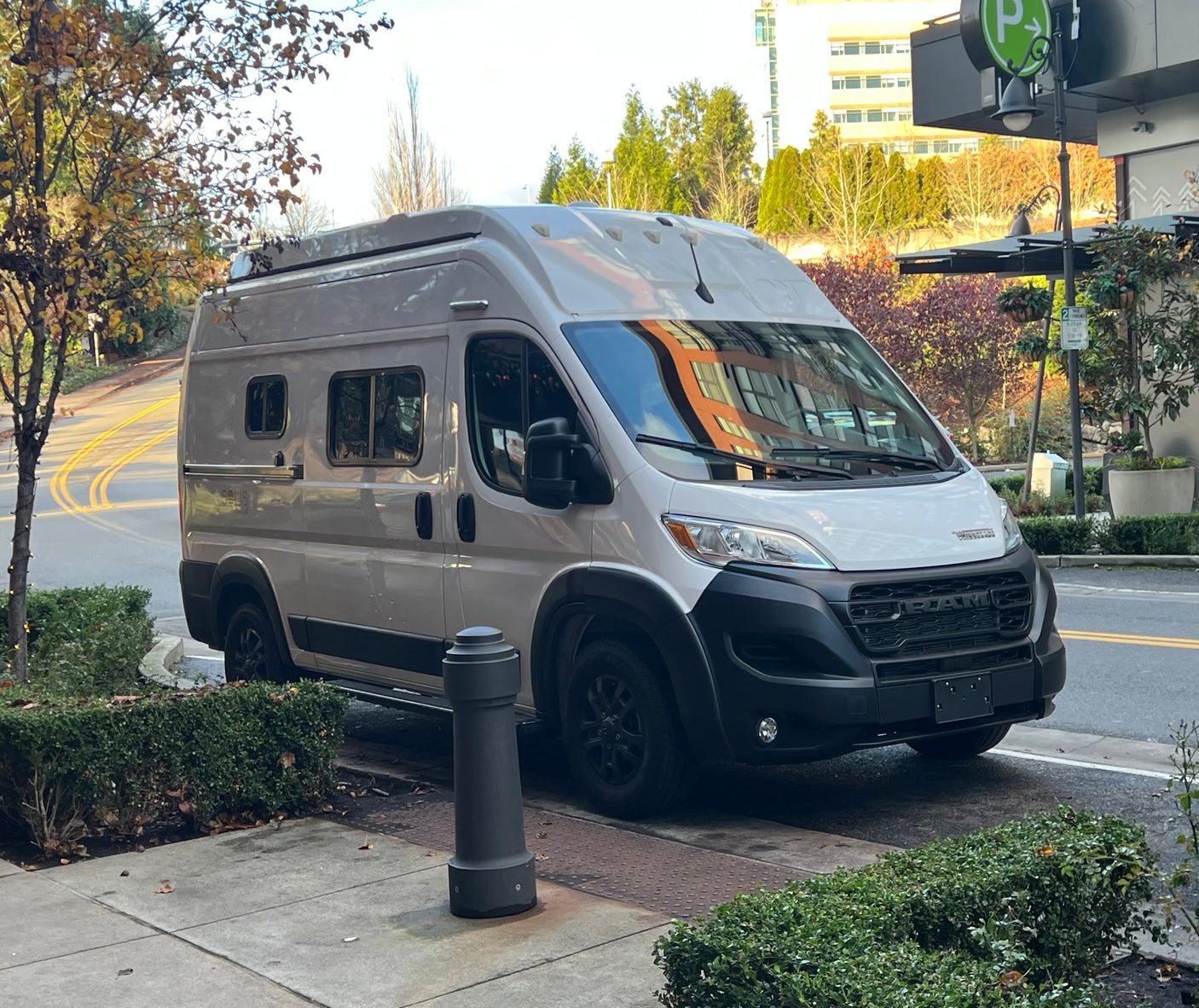 RV rental: A modern grey Winnebago Solis camper van parked on an urban street, ready for your next adventure.