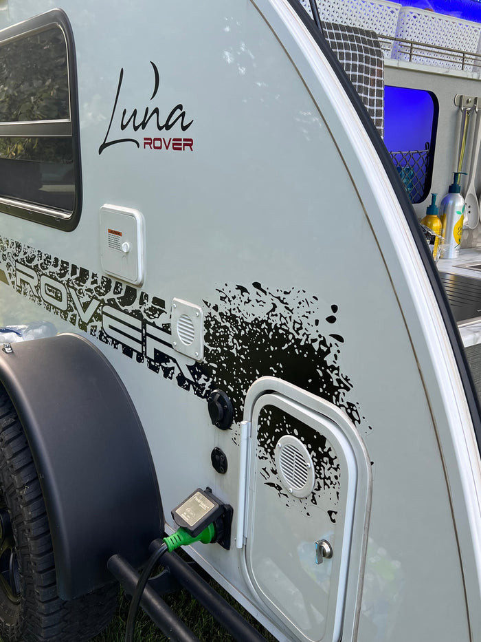 ready for outdoor cooking.|A white Luna Rover teardrop **RV rental** with open door