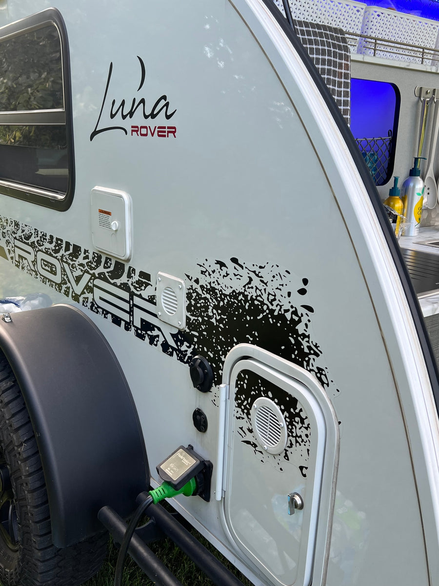 ready for outdoor cooking.|A white Luna Rover teardrop **RV rental** with open door