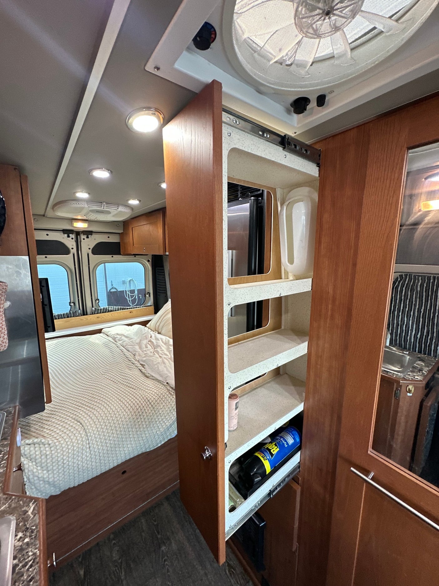 leading to the patterned bed.|An RV rental: a beige Ram ProMaster van