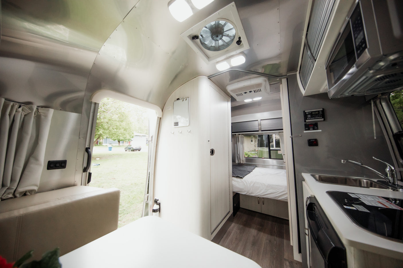 Discover a cozy rv rental interior! This modern Airstream features a compact kitchen, comfortable bed, and scenic outdoor views.