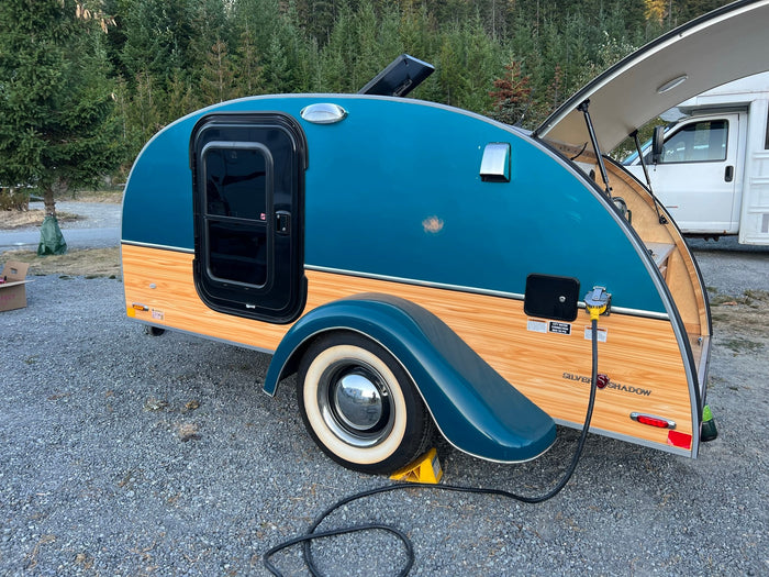 ideal for outdoor travel.|A retro teal and wood teardrop trailer RV rental