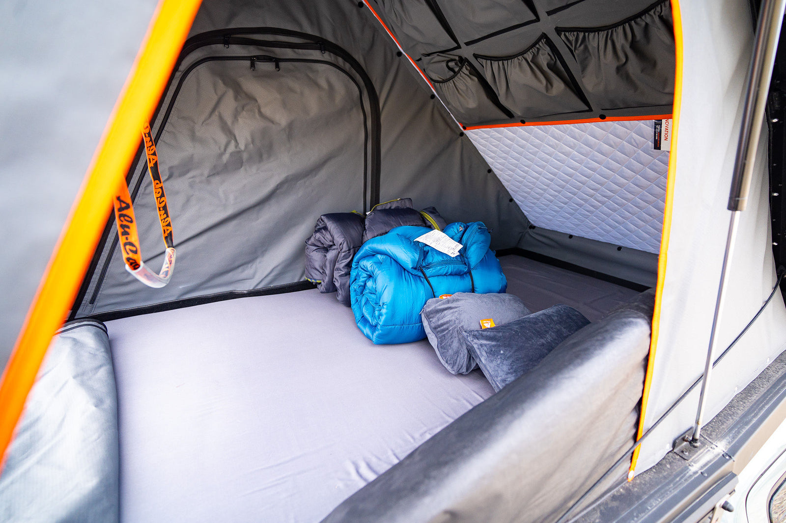 ideal for an overlanding rv rental adventure in nature.|Inside a comfy Alu-Cab rooftop tent for rv rental. Features a mattress