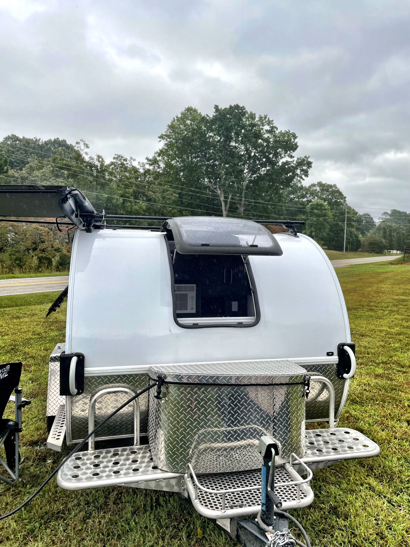 featuring a portable fire pit and chair.|Experience outdoor freedom with this compact teardrop RV rental