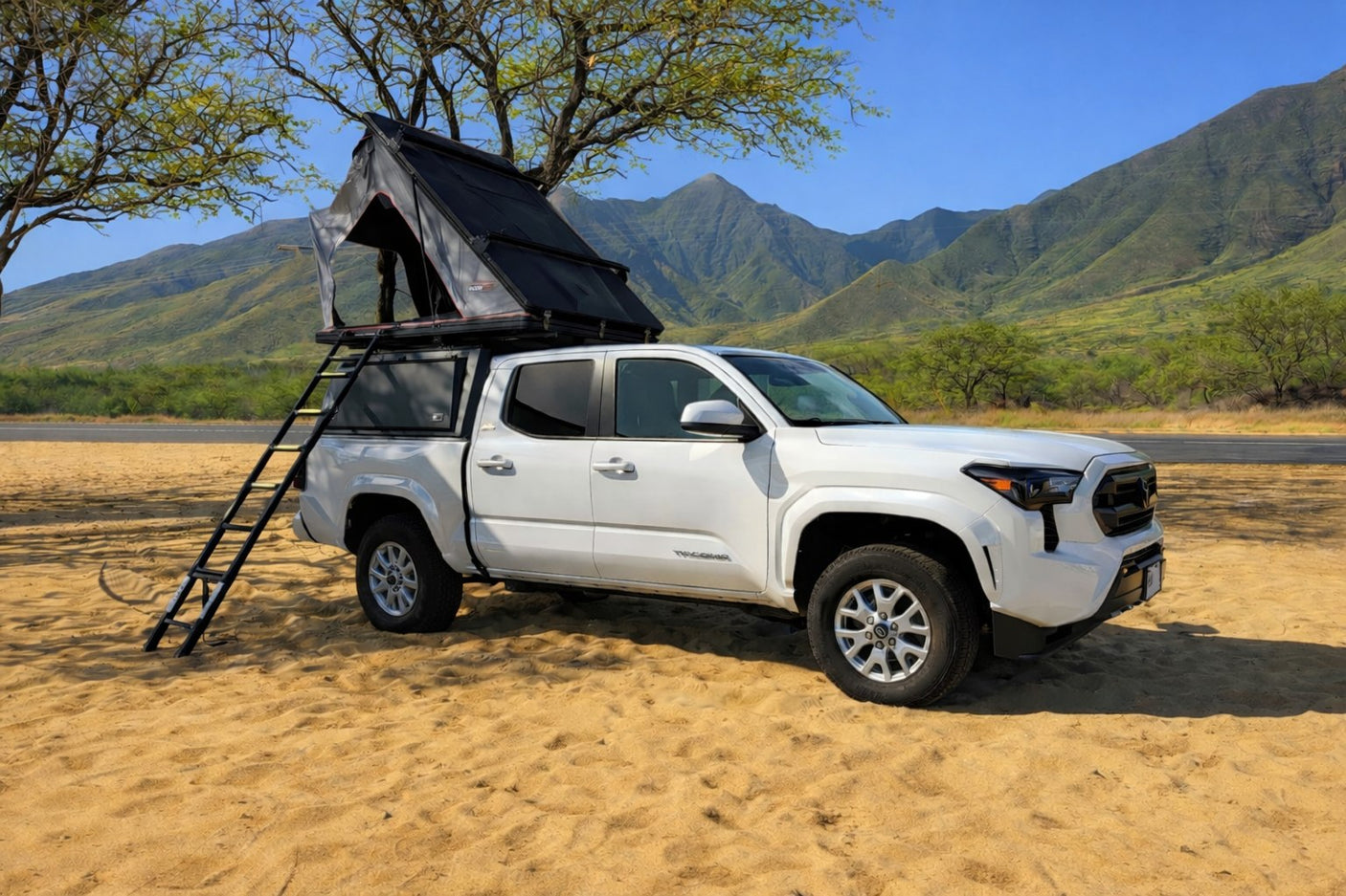 White Toyota Tacoma RV rental truck with an open rooftop tent