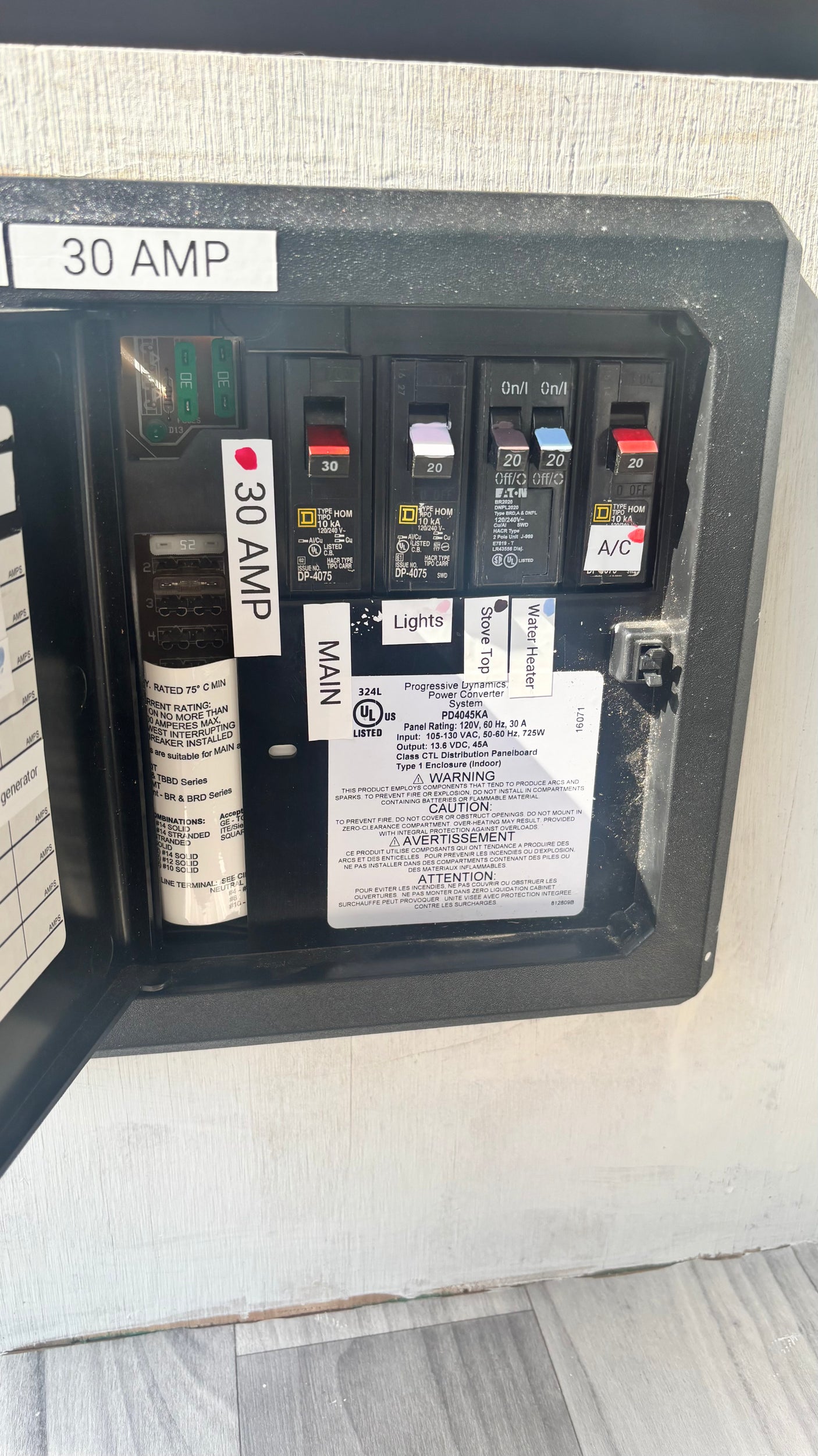 30 amp RV rental electrical panel, featuring circuit breakers for AC appliances and fuses for DC power distribution.
