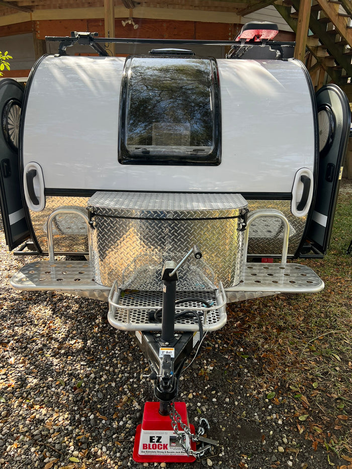 and outdoor adventure gear.|Blue truck with rv rental camper at a sunny campsite. Larger motorhomes and palm trees in this serene camping setting.|An rv rental teardrop trailer with a fully equipped outdoor kitchen