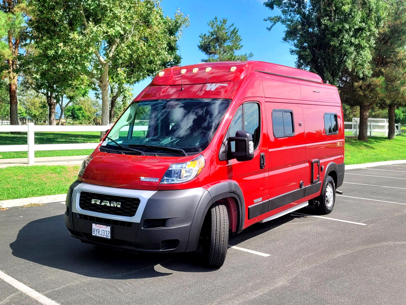 Bright red Winnebago Solis camper van, ideal for your next RV rental adventure, parked on a sunny day.