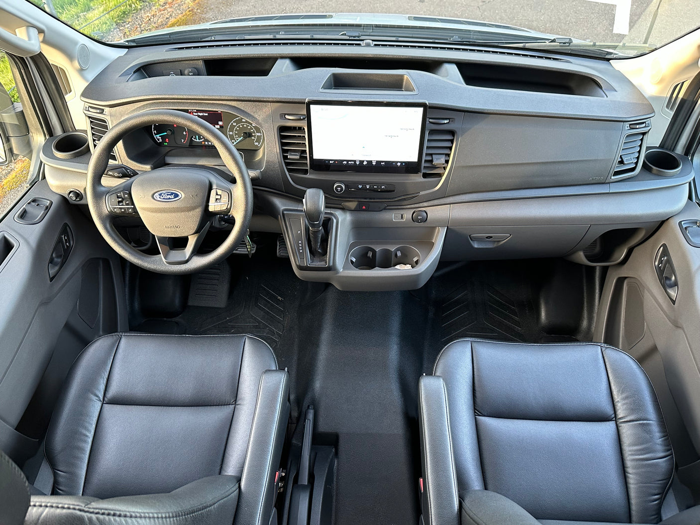 Modern Ford Transit van interior, featuring dashboard, touchscreen, and front seats, ready for rv rental.