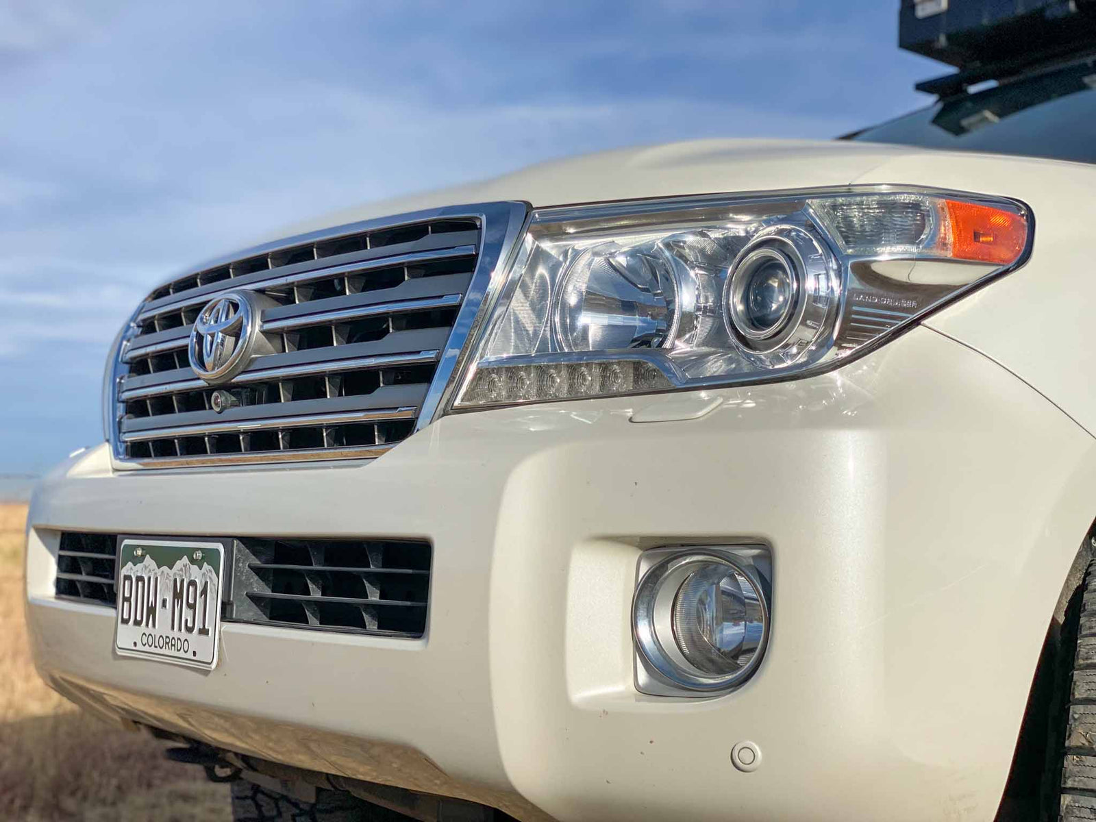 ready for off-road adventure.|White Titus Adventure Co. overland SUV (like an RV rental) with awning