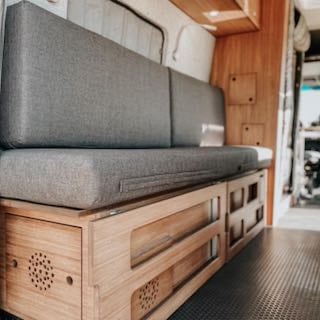 and shower.|Step into this custom RV rental camper van! Interior view from rear shows kitchen