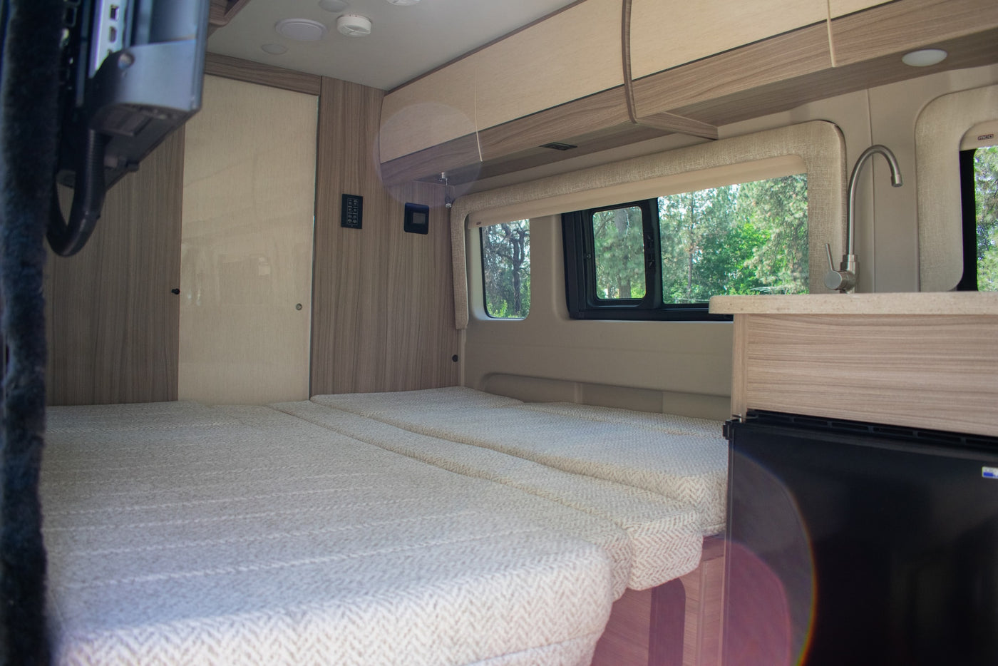 & green window view.|RV rental interior featuring a versatile bed — photo 12
