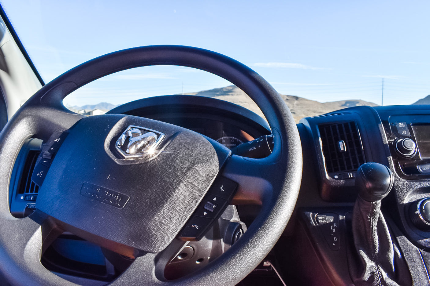 RV rental vehicle interior, showing steering wheel with Ram logo, dashboard controls, and automatic gear shifter.