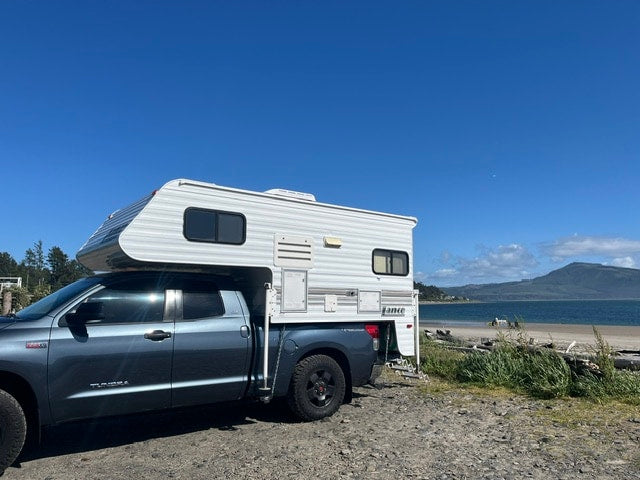 A blue truck with a white camper — photo 1