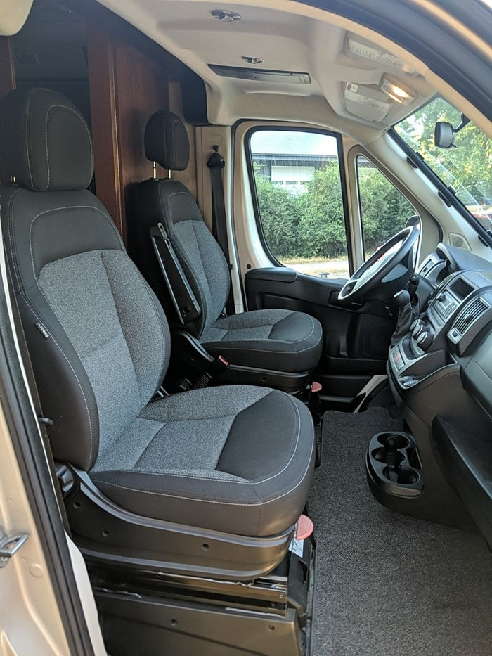 parked on a gravel lot under sunlight.|Tan rv rental van parked on a gravel driveway with sunlit trees. Ideal for your next outdoor adventure.|Overhead view of a compact RV rental interior. Shows cockpit